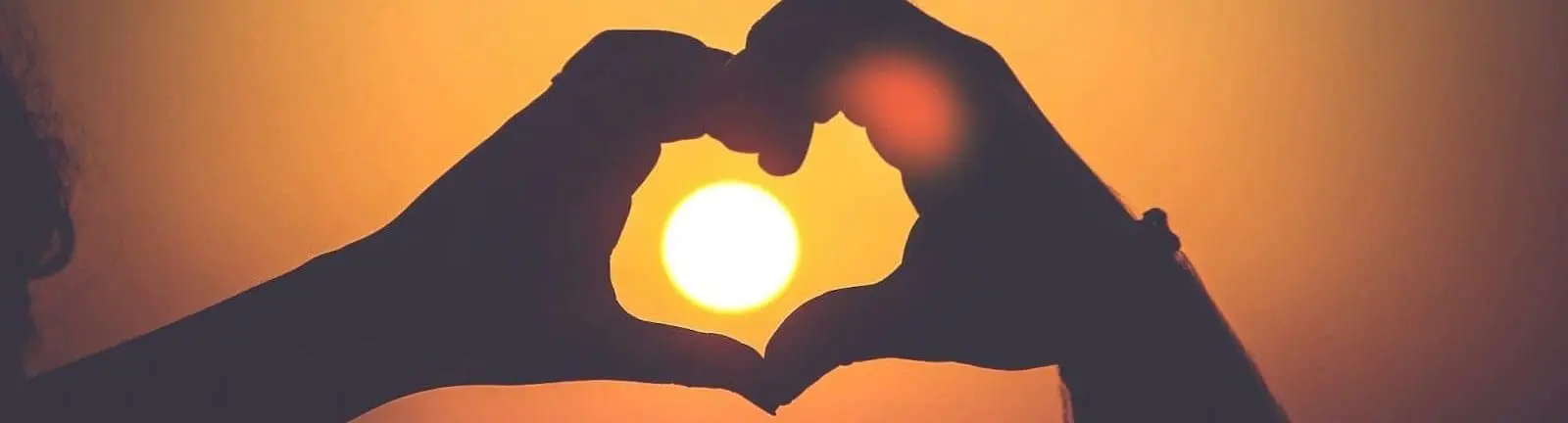 silhouette of person's hands forming heart